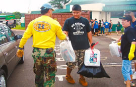 State Rep. Marcus Oshiro (back to camera), Leilehua students and teachers help residents unload their cars during a community recycling drive last month that earned thousands of dollars for the school. Photo from Rene Mansho.
