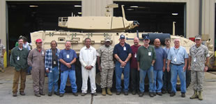Naval shipyard welders are at a Marine base in Georgia to reinforce vehicles like these for battle in Iraq. Among them are Pearl Harbor’s Michael Pascual and Gary Kalilikane (second and third from left) and Peter Hauanio (in white). Maj. Gen. Willie Williams, commanding general, stands at center in fatigues. Photo from U.S. Marine Corps.