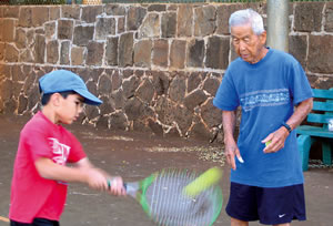 John Park monitors a return by his student Ian Linville at the Kaimuki Park tennis courts. Photo from Deborah Sharkey.