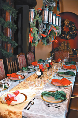 The dining table decorated with candles, pine and gold plates, an heirloom in the Chapman family for