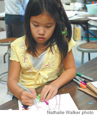 Hannah Noshioka, third grade, and Fin Merrill, second grade, work on art projects