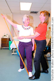 Physical therapist Lucy Lessard (right) assists Ruth Nugent with a resistance band exercise in prevention of osteoporosis