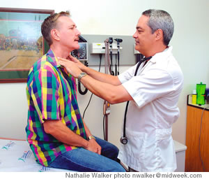 Dr. Elliot Kalauawa examines Michael Burnett at the Waikiki clinic