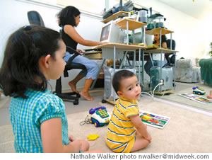 Melissa Layden works at home while children Molly and James play