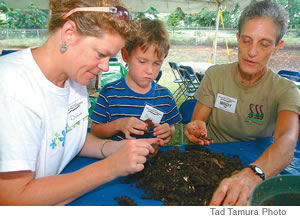 Getting their hands dirty, Donna Otto and son, Devin, separate worm compost with the help of conference organizer Mindy Jaffe