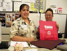 Times customer service rep. Kauionalani Sato and general clerk Debra Shimabuku display a Times reusable shopping bag