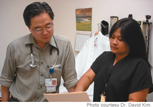 Dr. Kim and office manager Michelle Vidad discuss a patient's chart