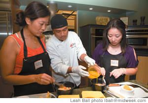 Chef Elmer Guzman shows Aya Ishizuka and Yukiko Ugajin how to do it