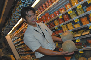 Foodland corporate chef Keoni Chang looks for sticky cantaloupes with a ‘bald spot’