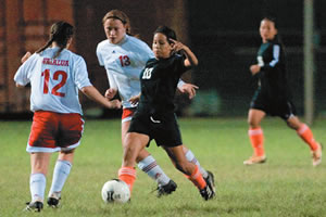 Campbell's Christiana Alcosiba (#10) sweeps the ball between Melanie Woods (#12) and Kacy Wilia (#13) of Waialua. 