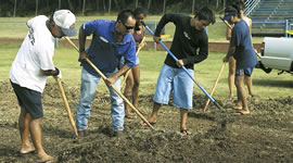 On July 5, Will Kimura, Matt Chang, Nicholas and Darlene Rosolowich and others helped prepare the Kailua football field for a delivery of sod from the Waialae Country Club. Photo by Byron Lee, staff photographer.