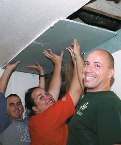 Volunteers Garry Nicholas and Rachel Elia help Doug Goodman (right) of Ohana Hou — an offshoot of the Windward Homeless Coalition — install drywall and floor tiles at a Hookipa housing unit to prepare the Kahaluu apartment for families in need. Photo by Byron Lee, staff photographer.