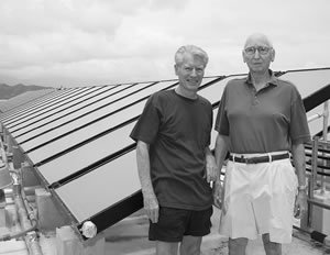 Building committee volunteers Ron Foster (left) and Jack Pentony stand by a few of the new solar panels on the rooftop of Windward Passage, Kailua’s 18-story condo that’s making great strides toward saving energy with its just completed renovation project. Photo by Byron Lee