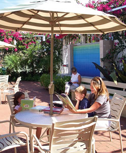 Cindy Iverson reads with her children Brooke and Joseph while Shirlee Dawson reads on a bench in the award-winning renovated courtyard at Kailua Library. Photo by Kalena Hayden.