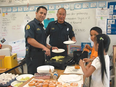 Firefighter Burnett and Capt. Ogata cooking green eggs and ham with Robyn Ide’s third-grade class