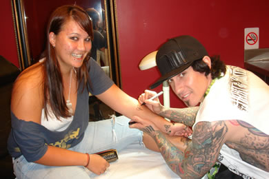 Stacie Takahashi gets a heart drawn on her arm by Carey Hart to be tattooed.