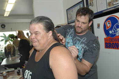 Lorie Duh of Waikiki gets an autograph on the back of her tank top from Duane Lee Chapman.
