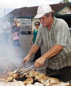 John Marquardsen is a hands-on chicken turner every Sunday in Haleiwa, and every Saturday (pictured above) at St. Mark Lutheran School in Kaneohe. Photo by Byron Lee