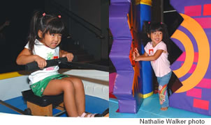 Hailey Kawamura plays on Rosita’s Locomotion while sister Mia makes her way through Super Grover’s Obstacle Course