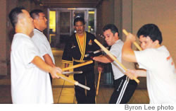 Greg Leong, Anthony Tanare, Abraham Rosario and Jordan Adaro practice with machetes and sticks under the watchful eye of grandmaster Tyron Takahashi.