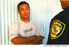 Guy Yoshimoto, a real cop who volunteers at the training academy, expresses his displeaure at being questioned by a police recruit, ends up getting cuffed (below)