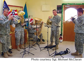 From left, with their automatic weapons within reach, Sgt. Brian Hull, Staff Sgt. Mark Goodier, Sgt. Quincy Dunker, Sgt. Michael McClaran and Spc. David Bustillos play Christmas music for the troops