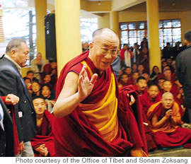 The Dalai Lama greets the crowd at the stadium