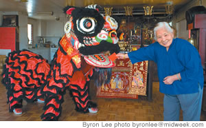 Cheng Yung Xing offers money to a lion for good luck