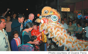 Chinatown revelers feed the lion money for good luck in the new year