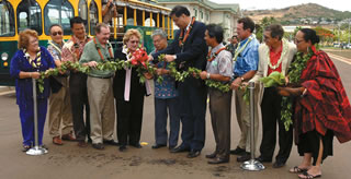 Mayor Hannemann oversees the untying of the maile, officially opening the new Kapolei road extension. Taking part in the celebration are (from left) Maeda Timson, Ken Kobatake, City Councilman Todd Apo, Steve MacMillan, Donna Goth, U.S. Sen. Dan Akaka, the mayor, City Councilman Nestor Garcia, Clint Churchill, R.J. Zlatoper and Kahu Nettie Tiffany. Photo courtesy of the James Campbell Company.