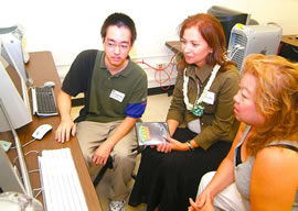 Student Jared Matsushige, Vivian Aiona (wife of Lt. Gov. Duke Aiona) and DOE teacher Colette Young-Pohlman view animation produced using the new UH render farm system at an Academy for Creative Media open-house at Leeward Community College. Photo from Kristen Bonilla.