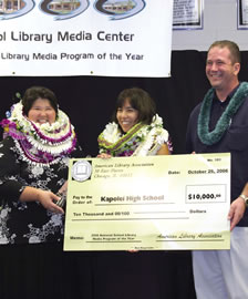 Kapolei High School Library media specialists Carolyn Kirio and Sandra Yamamoto accept a check from George Dragich, the account manager for Follett Library Resources. Photo by Vicky Nakasone-Pagaoa.