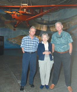 Martin Terii Vitousek (left) stands with his aunt Betty Vitousek and cousin Roy Vitousek III at the Pacific Aviation Museum Dec. 7, beneath the Aeronca plane his father and grandfather were flying the morning of the Japanese raid on Pearl Harbor. Photo by Nathalie Walker