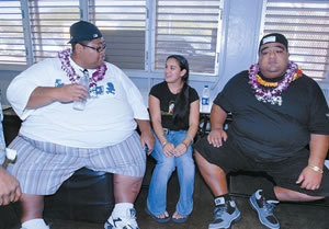 Konishiki Kid and Waianae High School senior Kathryn English sits between sumo greats Konishiki and Musashimaru during their Feb. 15 visit to her high school. Photo by Nathalie Walker